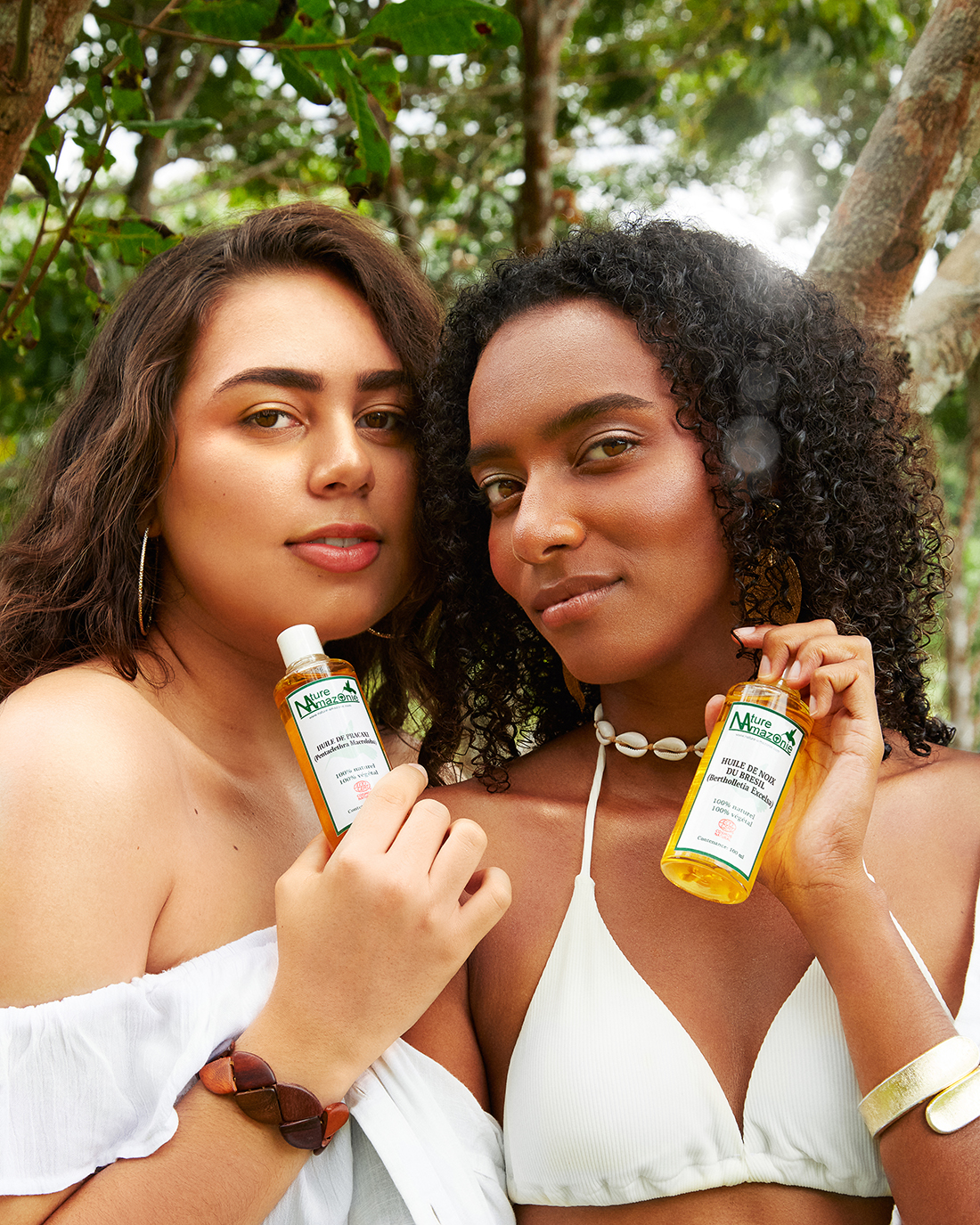 Photoshoot for Nature Amazonie : Two women holding oil bottles while smiling
