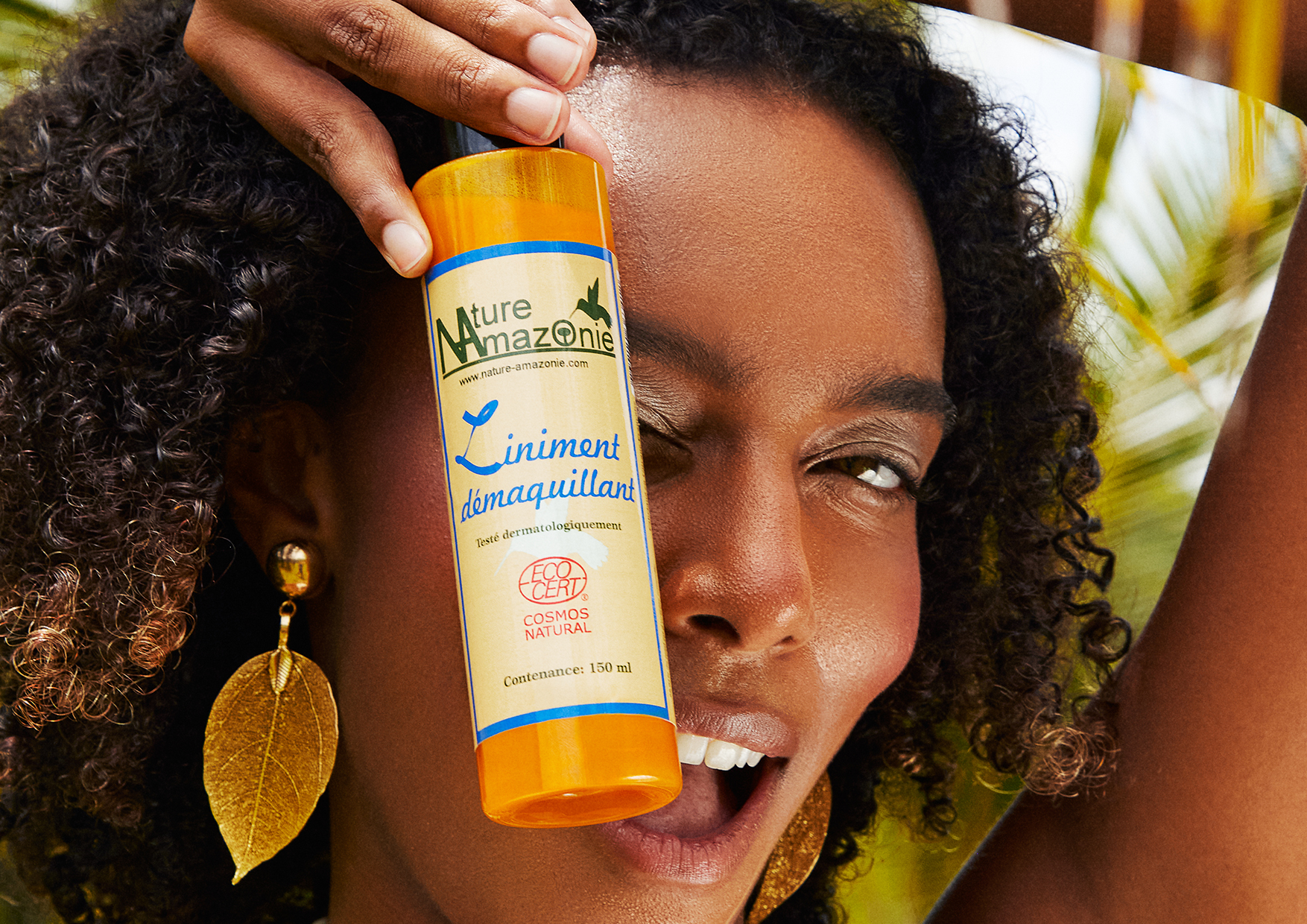 Photoshoot for Nature Amazonie : A woman holding a make-up remover bottle close to her face